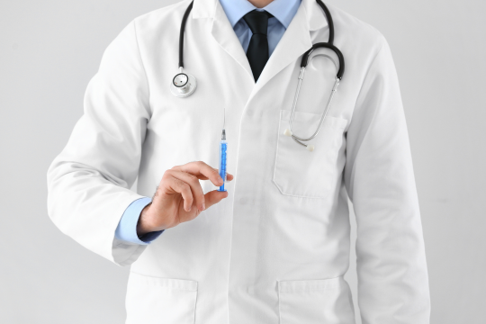 注射を持つ医者